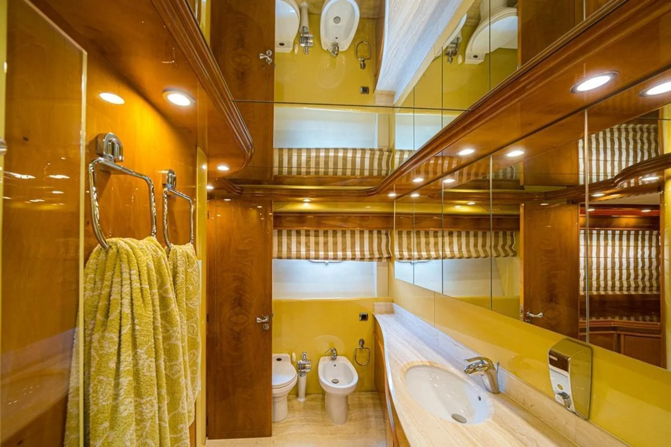 The yacht's bathroom features elegant wood paneling, a spacious countertop, and modern fixtures. aboard ASTONDOA 82 GLX Yacht for Sale