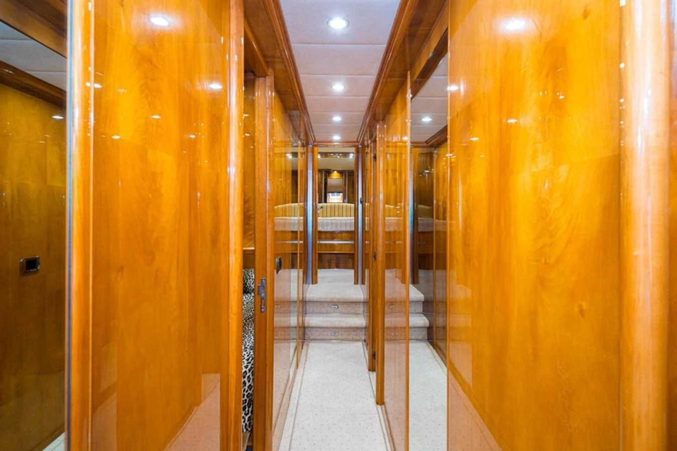 A polished wooden hallway leads to a cozy seating area on this luxurious yacht. aboard ASTONDOA 82 GLX Yacht for Sale
