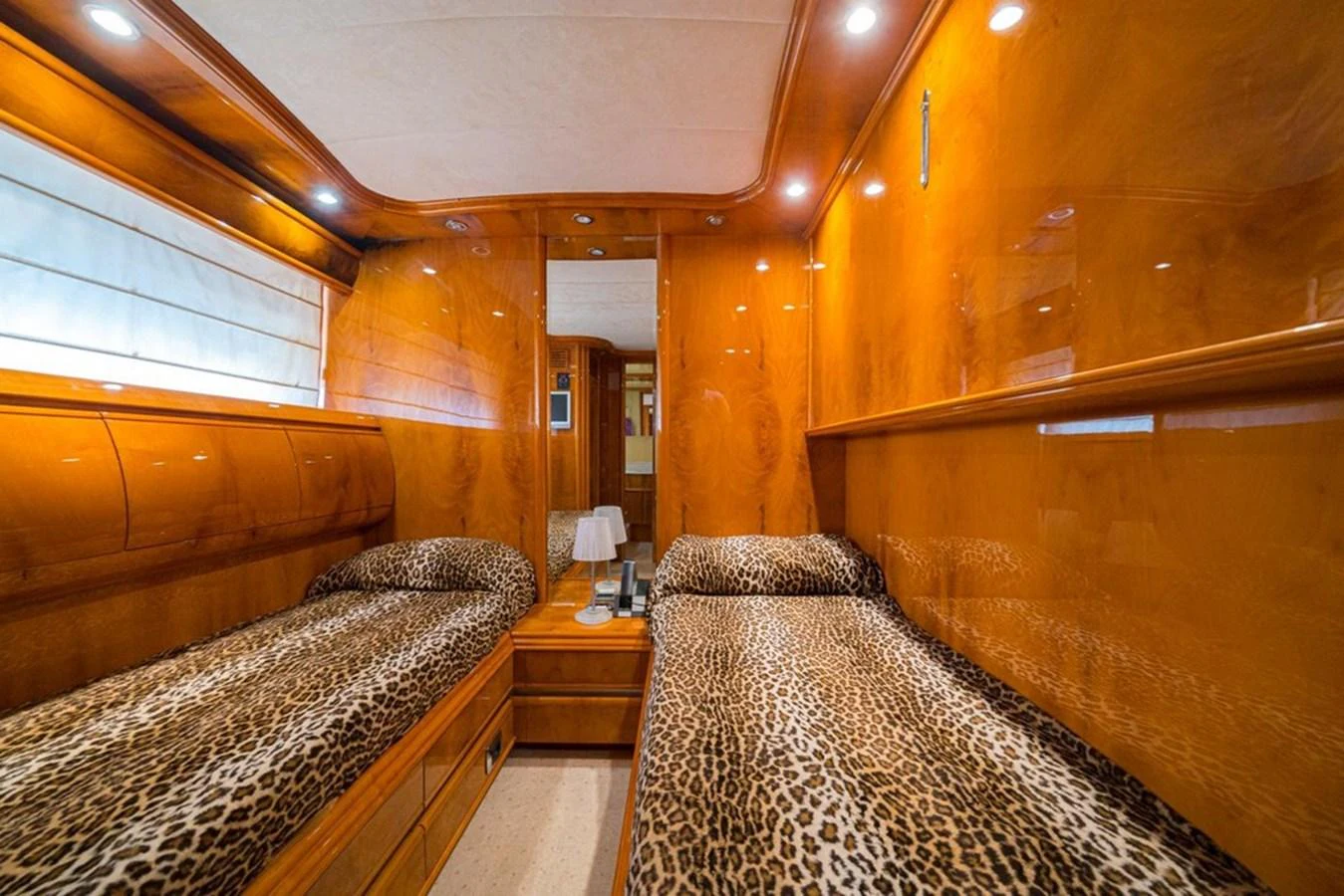 The twin stateroom features luxurious wood paneling and leopard print bedding, creating a warm and inviting atmosphere. aboard ASTONDOA 82 GLX Yacht for Sale