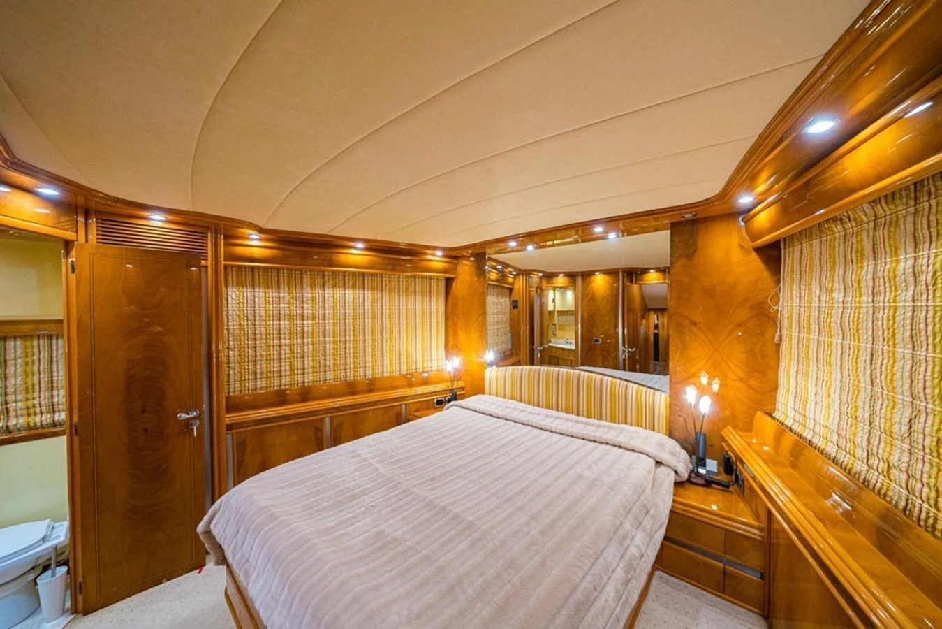 The master stateroom features a luxurious bed with elegant wood paneling and ambient lighting. aboard ASTONDOA 82 GLX Yacht for Sale
