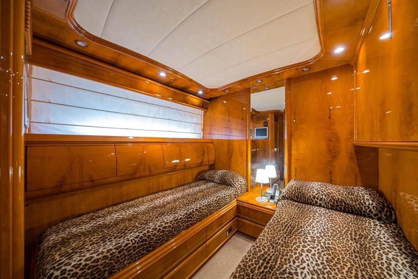 The twin stateroom features luxurious wood paneling and leopard print bedding, creating a warm and inviting atmosphere. aboard ASTONDOA 82 GLX Yacht for Sale