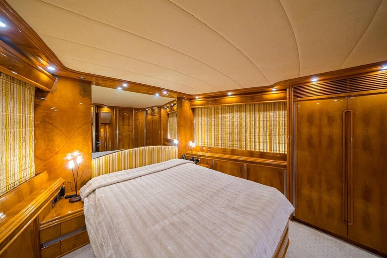 The master stateroom features a luxurious bed with elegant wood paneling and ambient lighting. aboard ASTONDOA 82 GLX Yacht for Sale