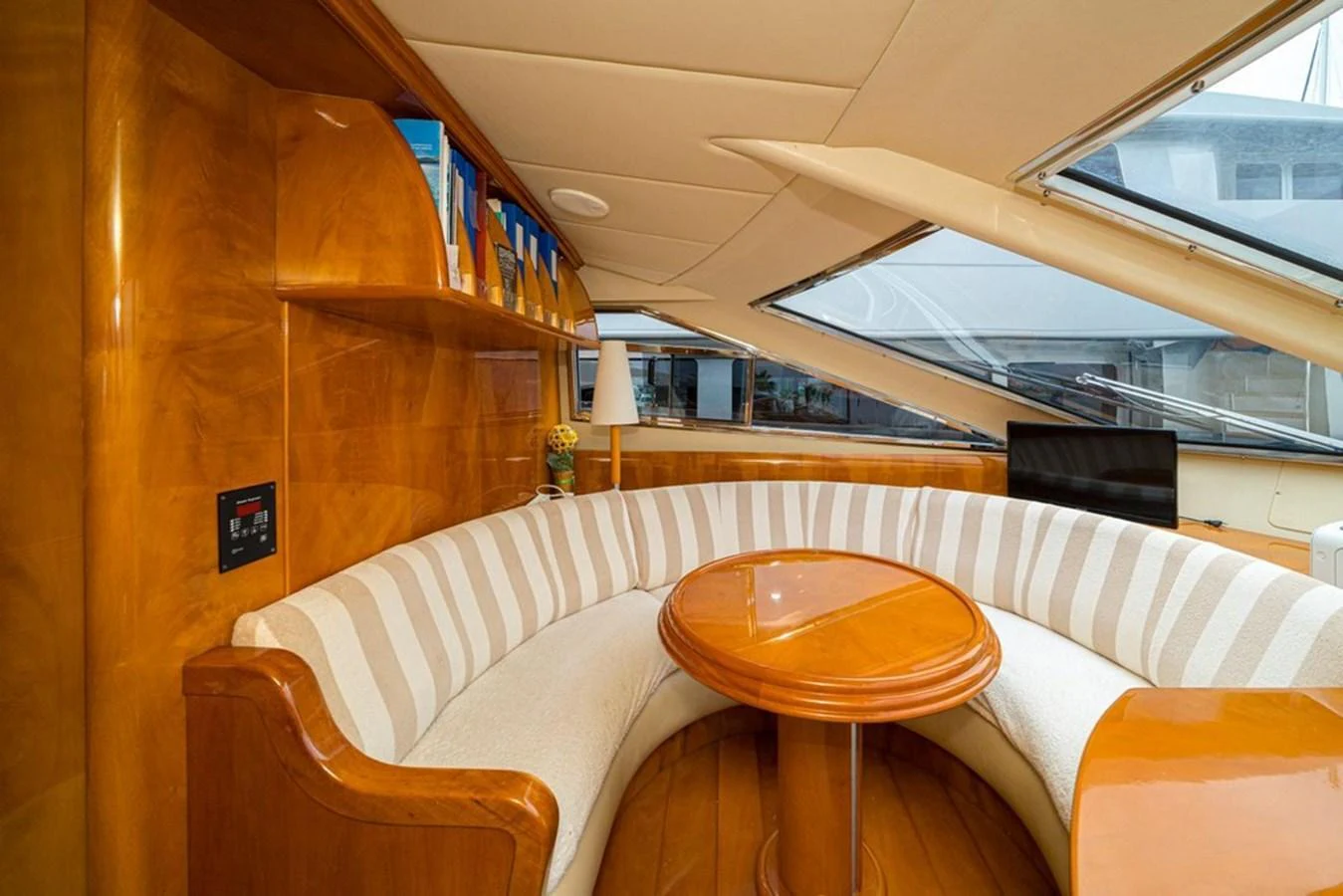 The salon features a cozy circular seating area with a wooden table and ample natural light. aboard ASTONDOA 82 GLX Yacht for Sale