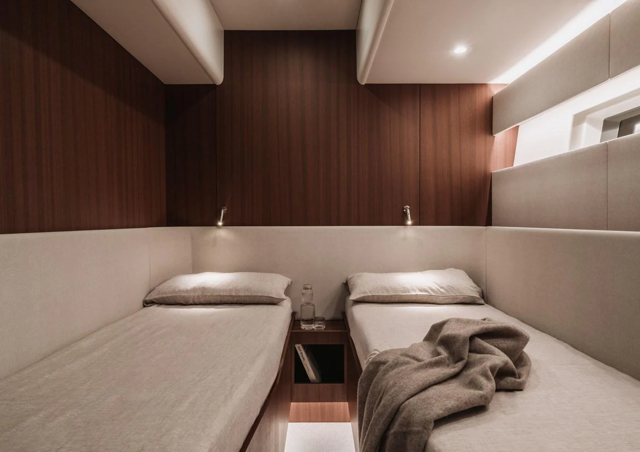 The guest cabin features twin beds with a warm, inviting ambiance. aboard 2026 YYACHTS Y8 Yacht for Sale