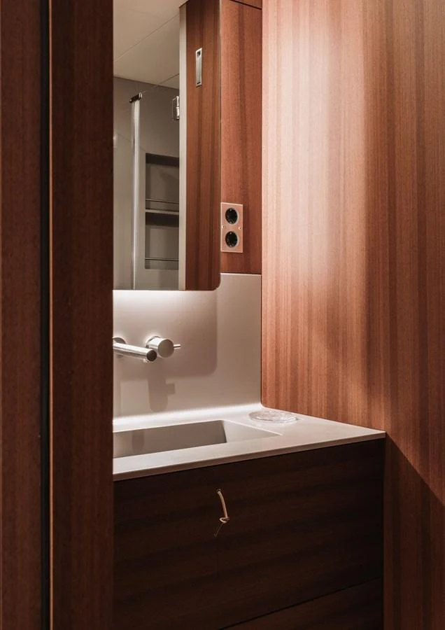 A sleek and modern yacht bathroom with wooden paneling and a minimalist sink. aboard 2026 YYACHTS Y8 Yacht for Sale