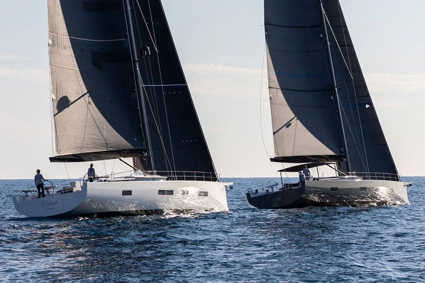 Two sleek sailing yachts glide gracefully on the open water under clear skies. aboard 2026 YYACHTS Y7 Yacht for Sale