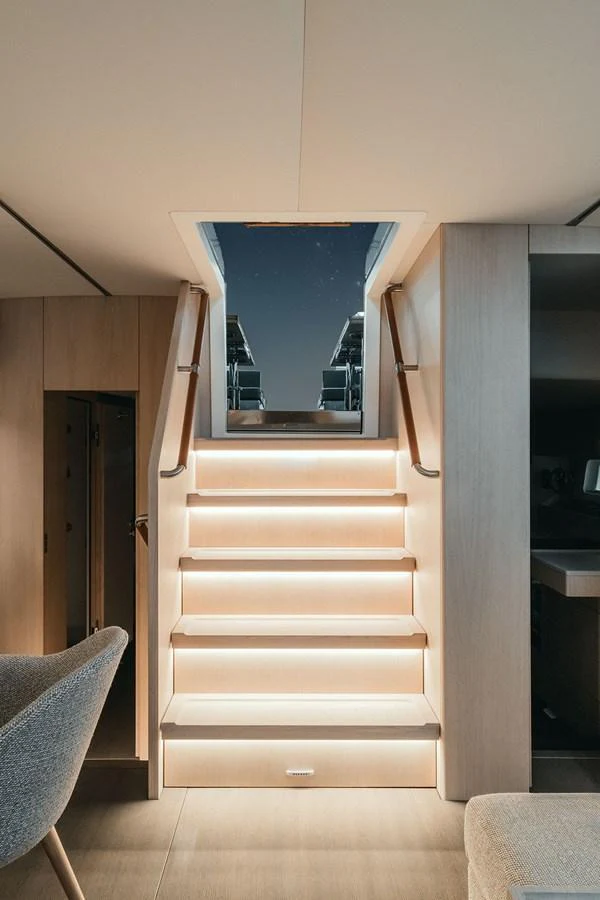 A beautifully lit staircase leads to the upper deck, showcasing modern design and elegance. aboard 2026 YYACHTS Y7 Yacht for Sale