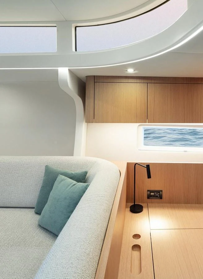 The yacht's interior features a cozy seating area with modern design elements and a view of the sea through the window. aboard 2026 YYACHTS Y7 Yacht for Sale