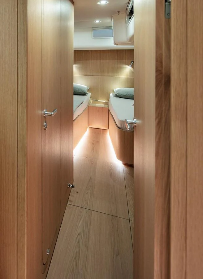 The image showcases a cozy cabin with twin beds and warm wooden finishes. aboard 2026 YYACHTS Y7 Yacht for Sale