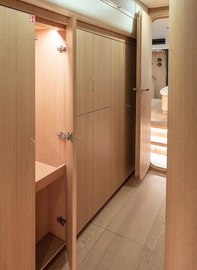 The image showcases a hallway with wooden cabinetry and steps leading to another area inside the yacht. aboard 2026 YYACHTS Y7 Yacht for Sale