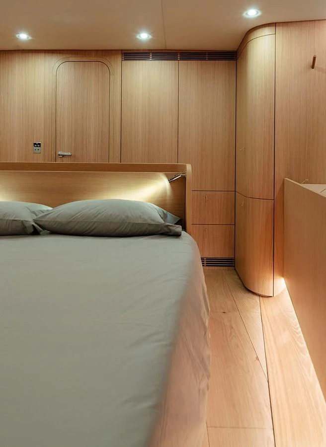 The stateroom features a minimalist design with warm wood paneling and soft lighting. aboard 2026 YYACHTS Y7 Yacht for Sale
