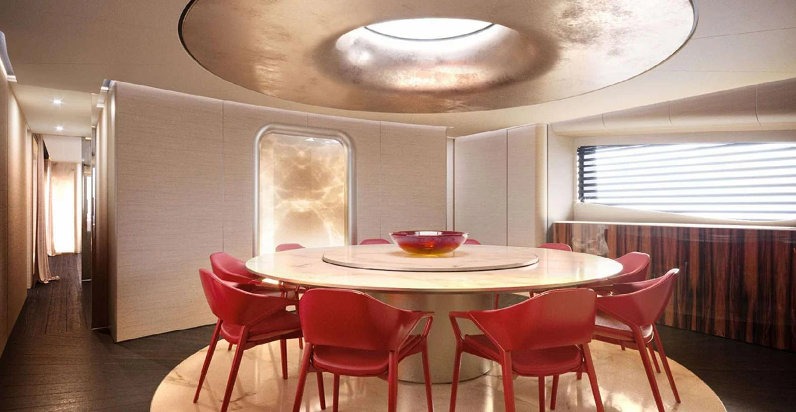 The yacht's dining area features a modern round table with vibrant red chairs and a stylish ceiling light. aboard T-EVO 120 Yacht for Sale