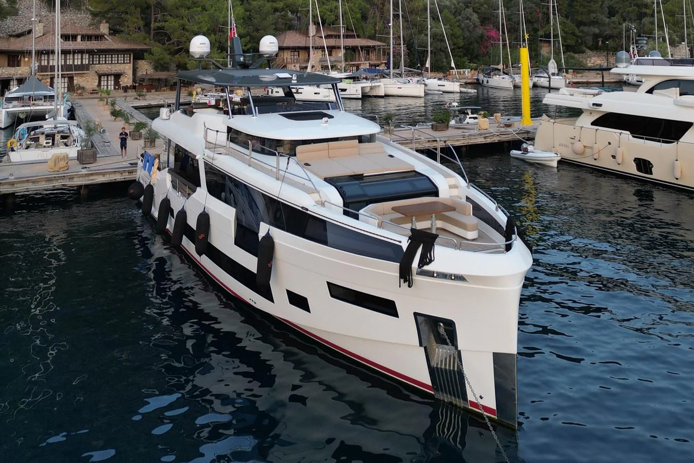 A sleek and modern yacht docked at a marina, showcasing its elegant design and spacious deck areas. aboard 2024 SIRENA 88 Yacht for Sale