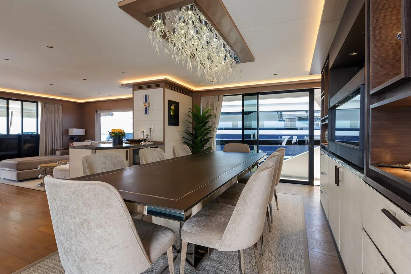 The yacht's dining area features a modern table with plush seating and elegant lighting. aboard 2024 SIRENA 88 Yacht for Sale