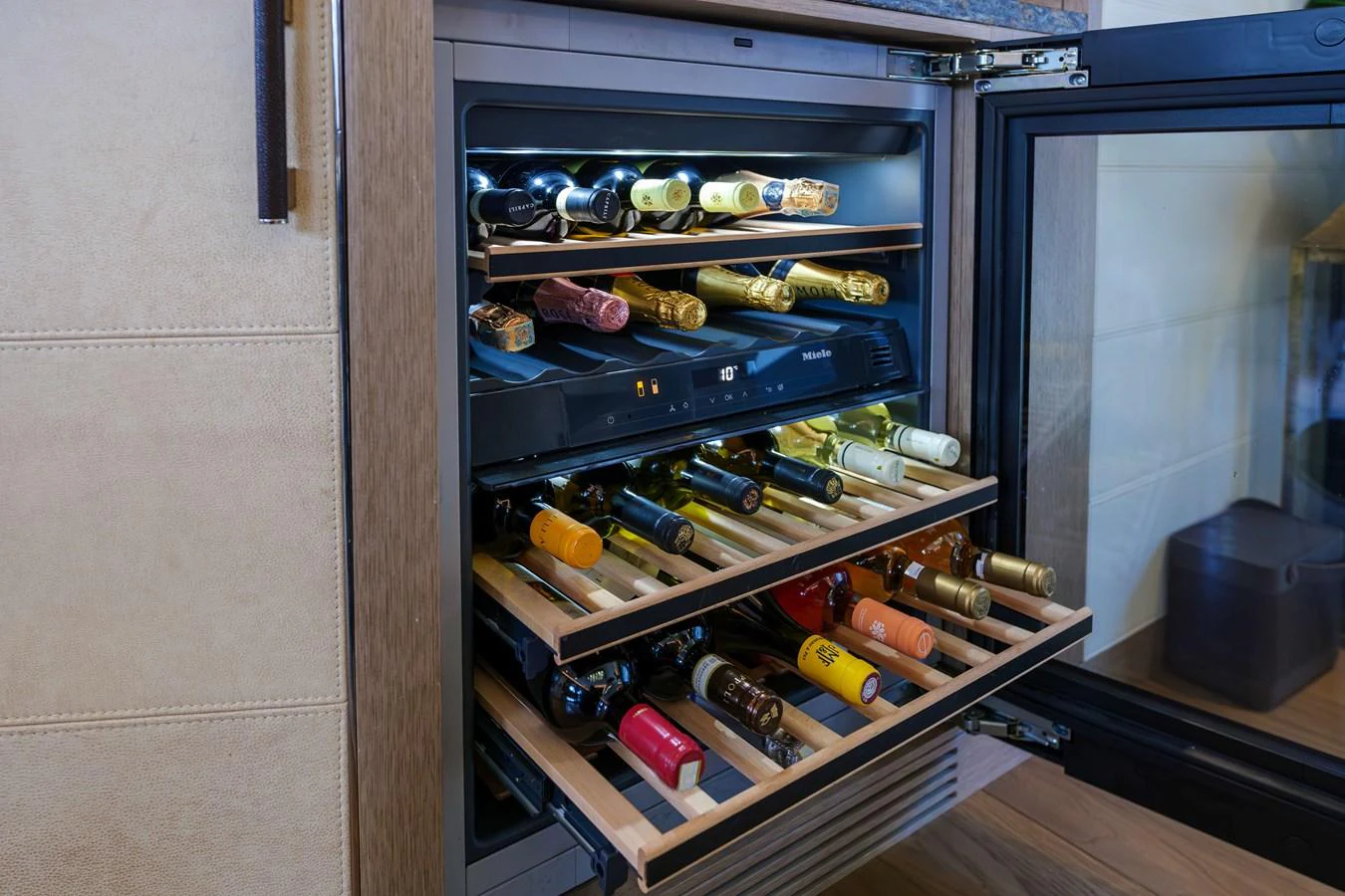 A well-stocked wine cooler with multiple shelves of assorted wines. aboard 2024 SIRENA 88 Yacht for Sale