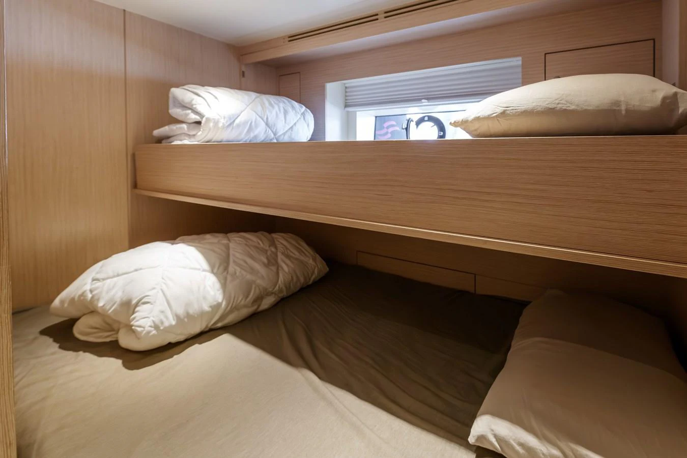 The image showcases a cozy bunk cabin with neatly arranged bedding. aboard 2024 SIRENA 88 Yacht for Sale