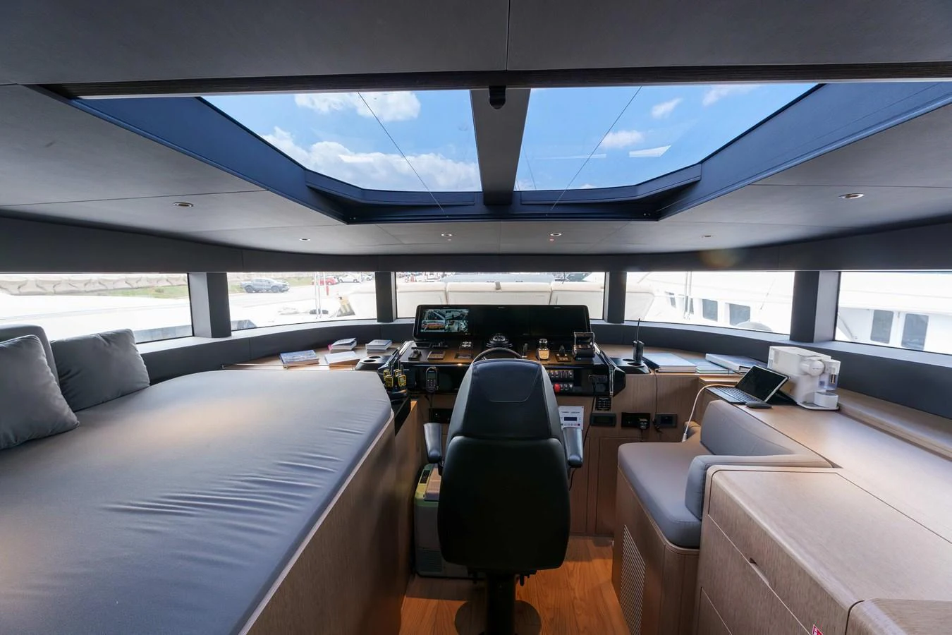 The helm station features a sleek, modern design with panoramic windows and a skylight for ample natural light. aboard 2024 SIRENA 88 Yacht for Sale