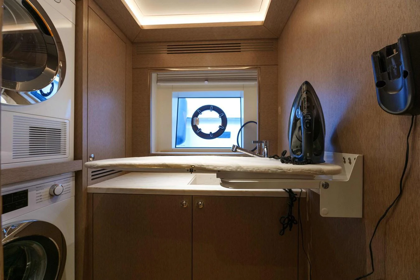 The yacht's laundry room is equipped with modern appliances and an ironing station. aboard 2024 SIRENA 88 Yacht for Sale