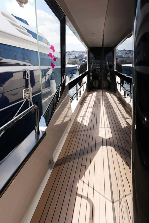 The side deck features sleek lines and polished wood flooring, offering a seamless passage along the yacht. aboard 2024 SIRENA 88 Yacht for Sale