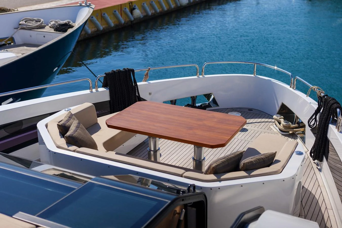 The foredeck features a cozy seating area with a wooden table, perfect for enjoying the view. aboard 2024 SIRENA 88 Yacht for Sale