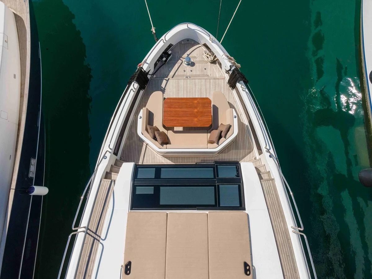 The foredeck of the yacht features a cozy seating area with a wooden table, perfect for relaxation and socializing. aboard 2024 SIRENA 88 Yacht for Sale