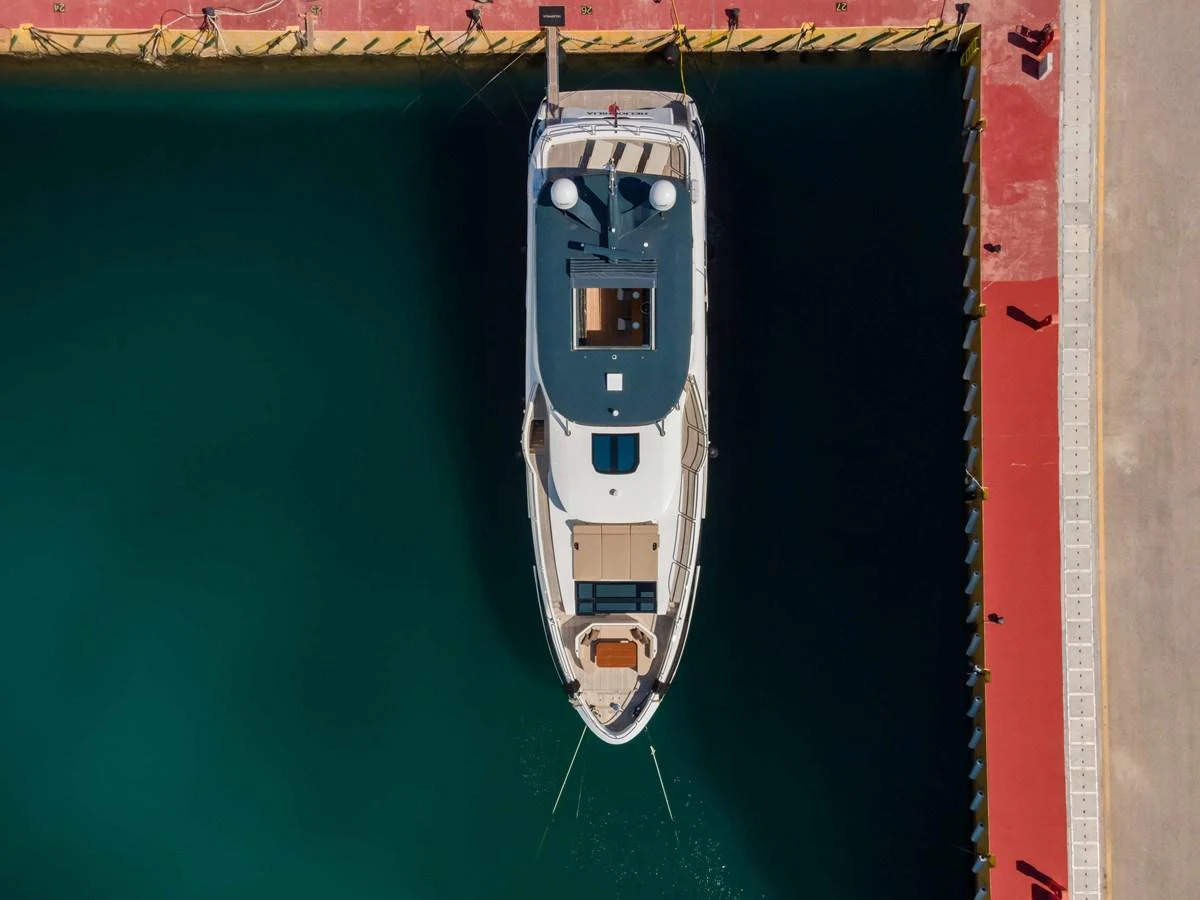The yacht is docked at a marina, viewed from above, showcasing its sleek design and spacious deck areas. aboard 2024 SIRENA 88 Yacht for Sale