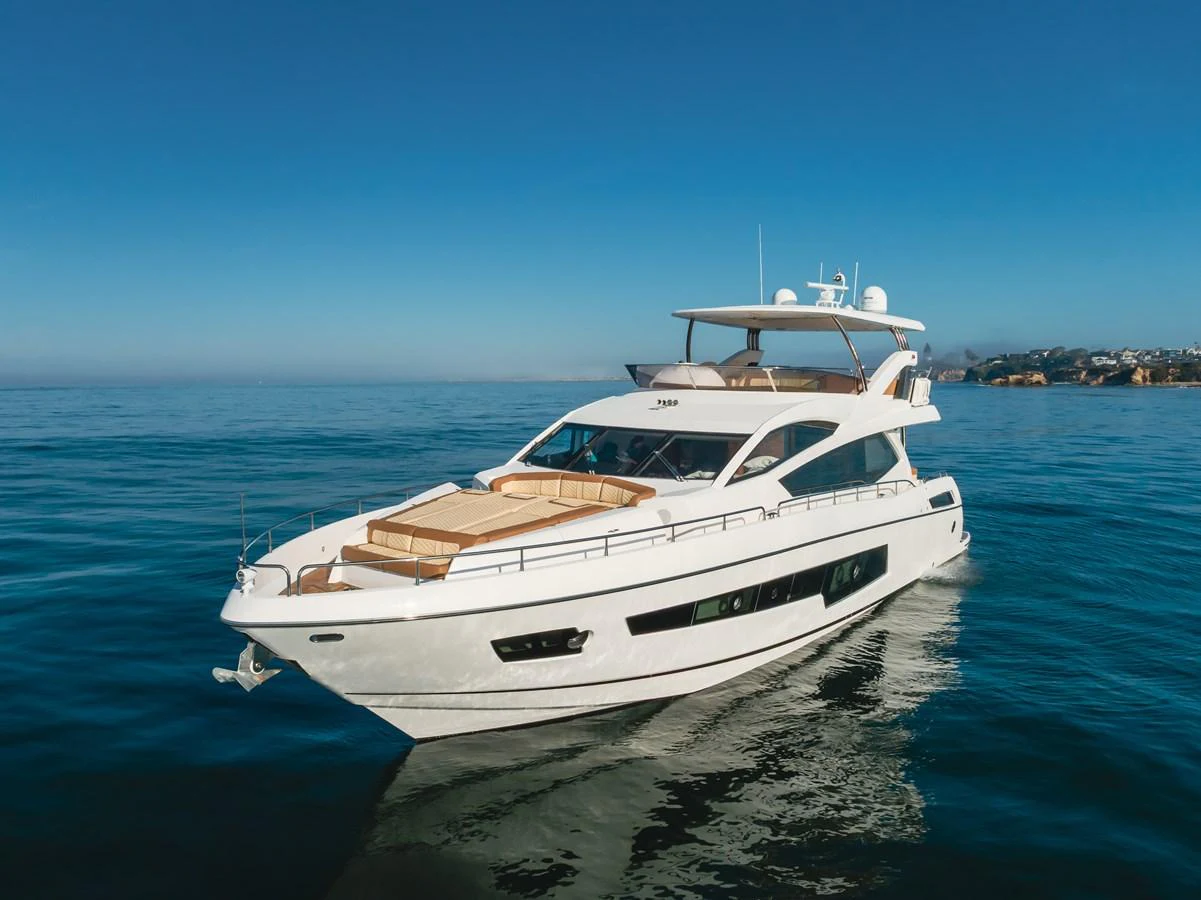 A sleek and modern yacht cruising on calm waters under a clear blue sky. aboard AGUA RANCHO Yacht for Sale