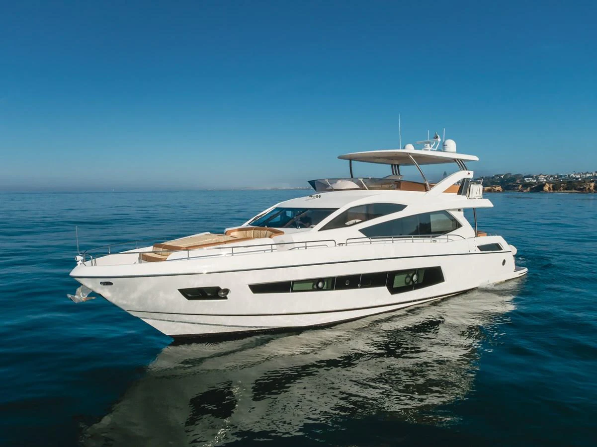 A sleek and modern yacht cruising on calm waters under a clear blue sky. aboard AGUA RANCHO Yacht for Sale