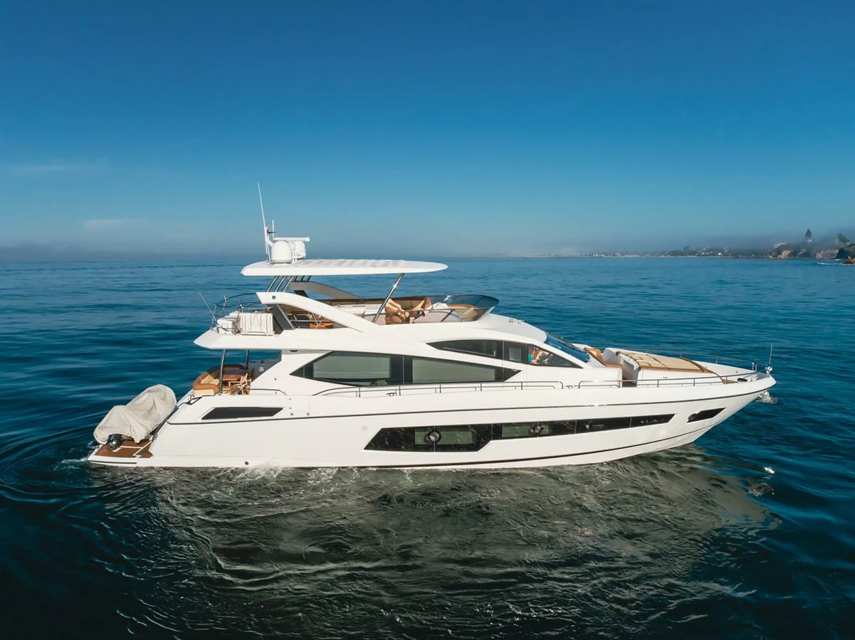 A sleek and modern yacht glides gracefully on the open water under a clear blue sky. aboard AGUA RANCHO Yacht for Sale