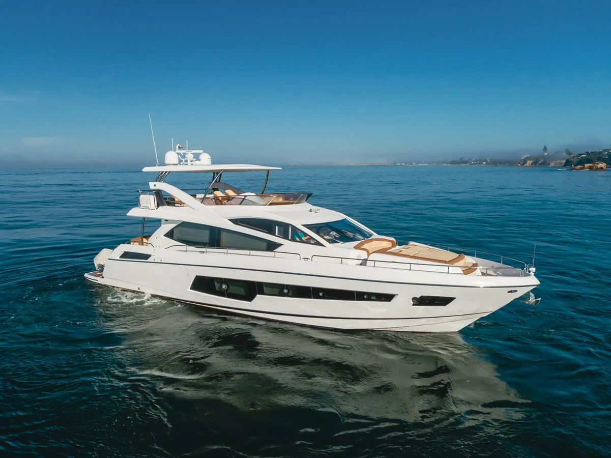 A sleek and modern yacht glides gracefully on calm waters under a clear blue sky. aboard AGUA RANCHO Yacht for Sale