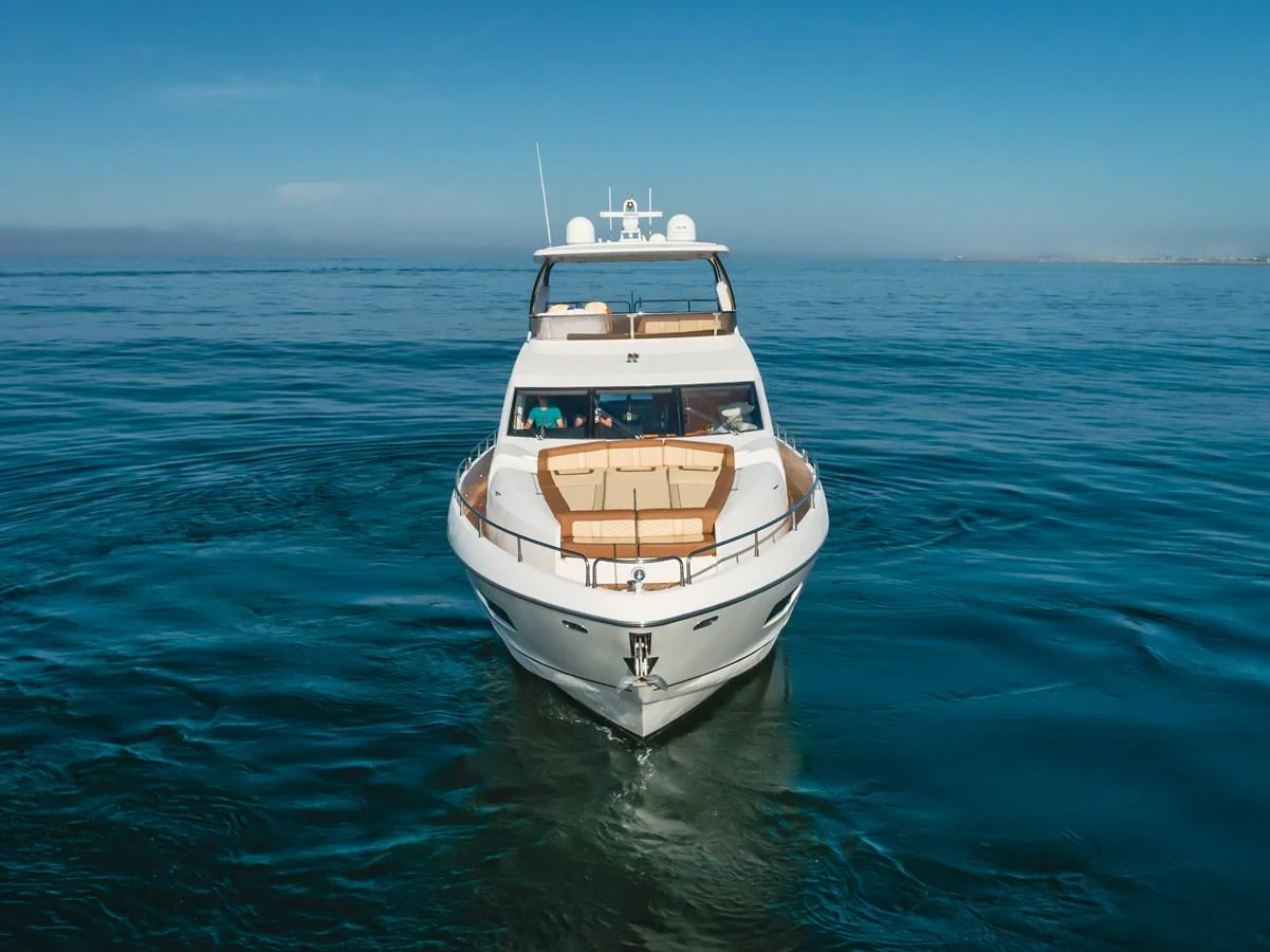 A sleek yacht cruises gracefully on calm waters under a clear blue sky. aboard AGUA RANCHO Yacht for Sale
