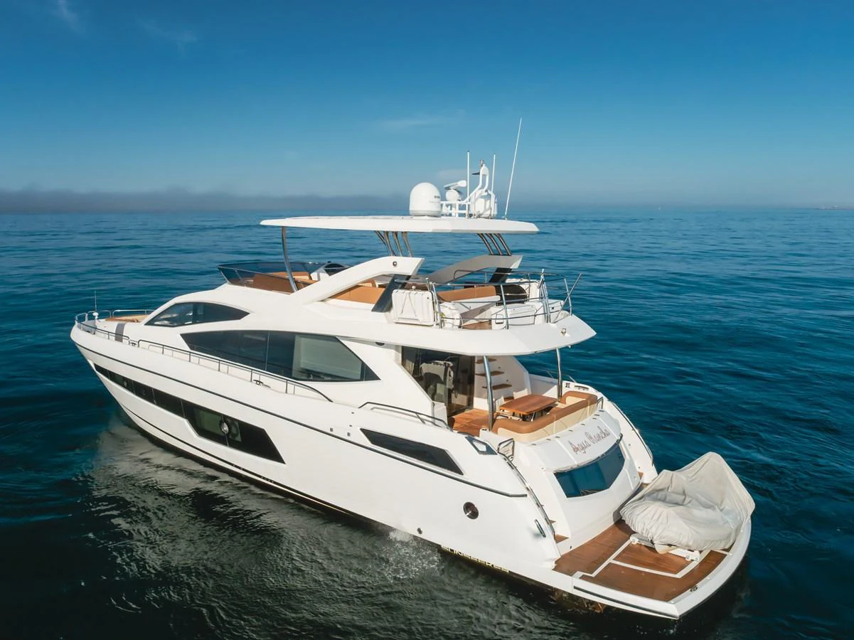 A sleek and modern yacht cruising on calm blue waters under a clear sky. aboard AGUA RANCHO Yacht for Sale