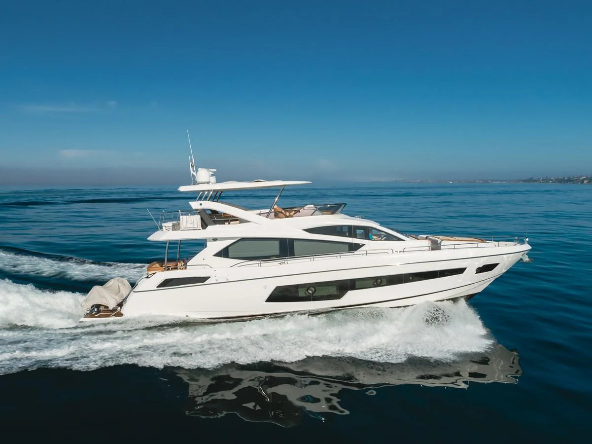 A sleek and modern yacht cruises smoothly on the open water under a clear blue sky. aboard AGUA RANCHO Yacht for Sale