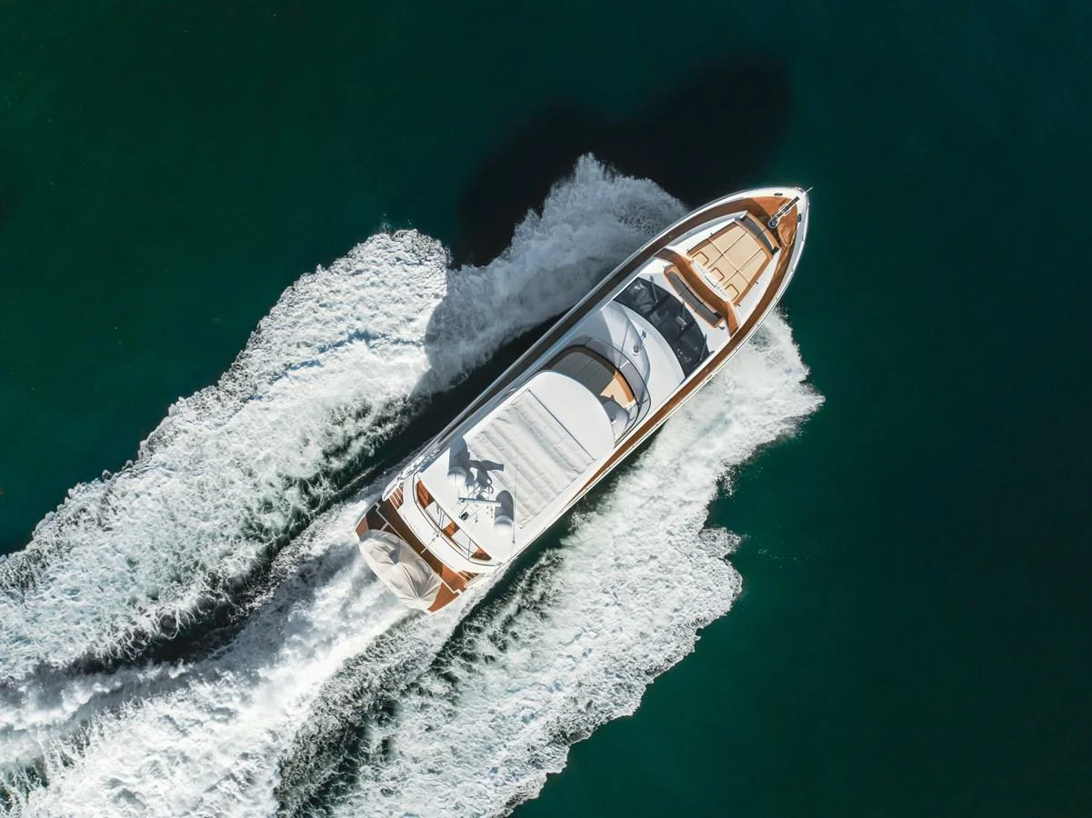 A sleek yacht cruises through the water, leaving a trail of white wake behind. aboard AGUA RANCHO Yacht for Sale