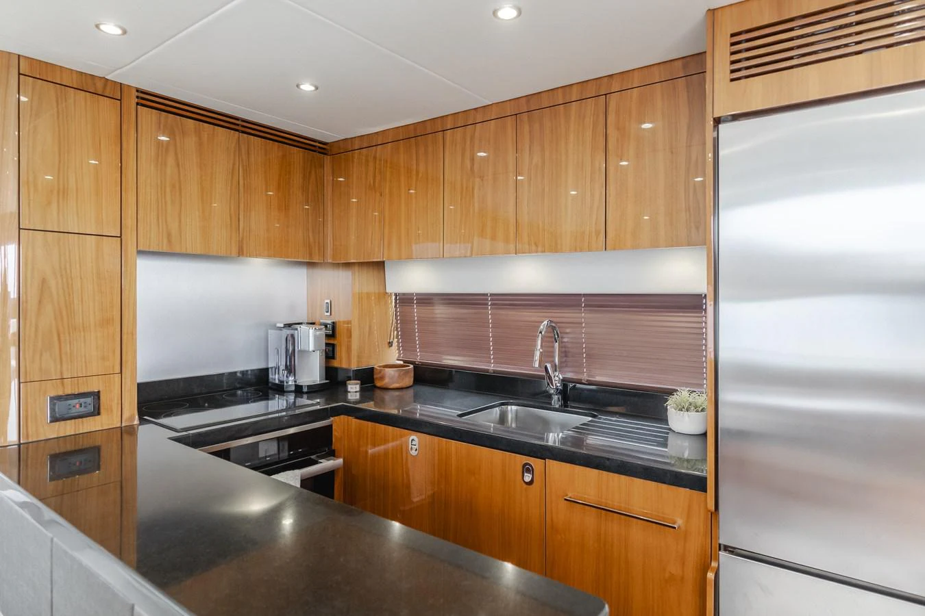 The galley features sleek wooden cabinetry, modern appliances, and a polished countertop. aboard AGUA RANCHO Yacht for Sale