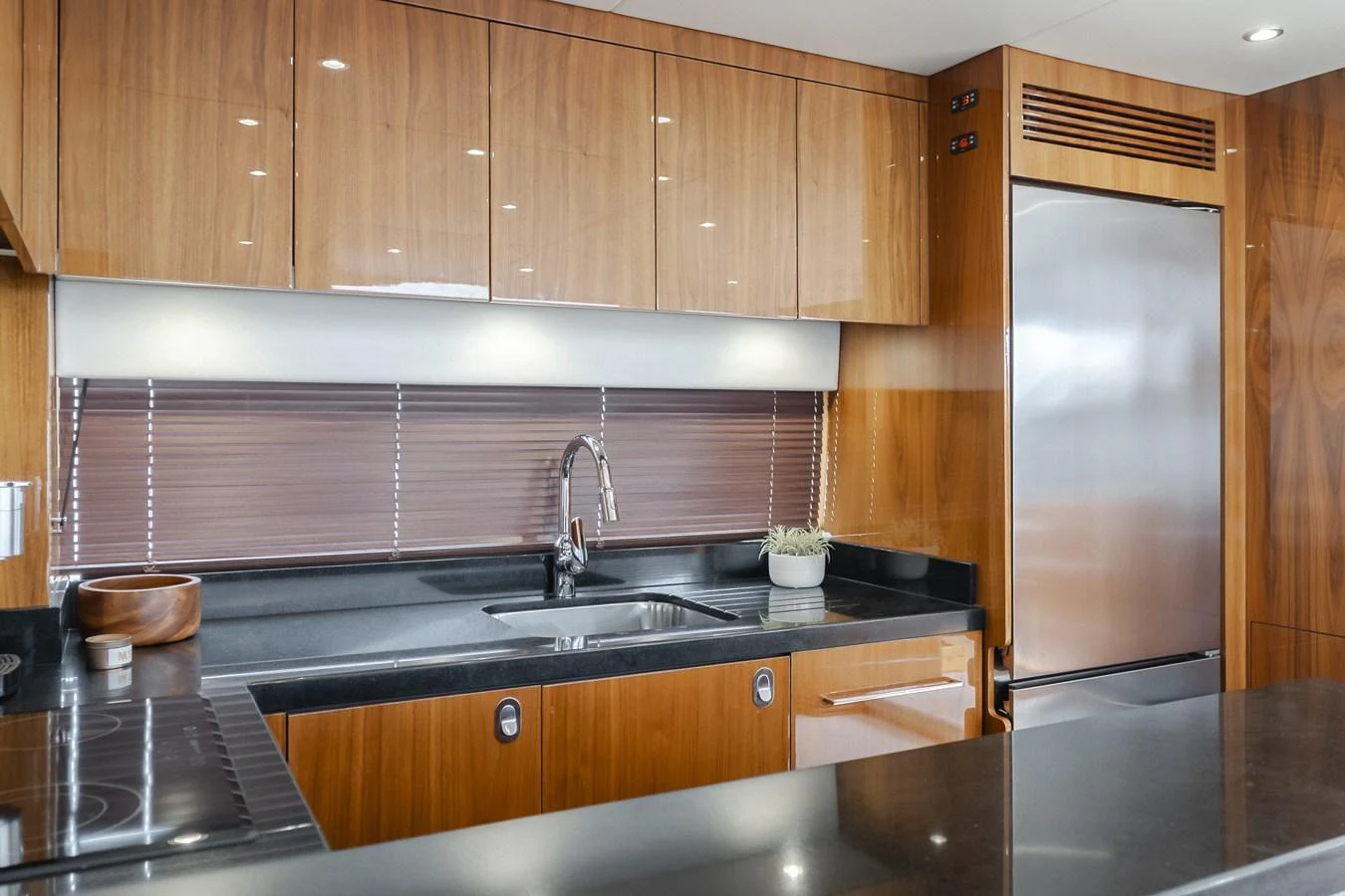 The yacht's galley features sleek wooden cabinetry and modern stainless steel appliances. aboard AGUA RANCHO Yacht for Sale