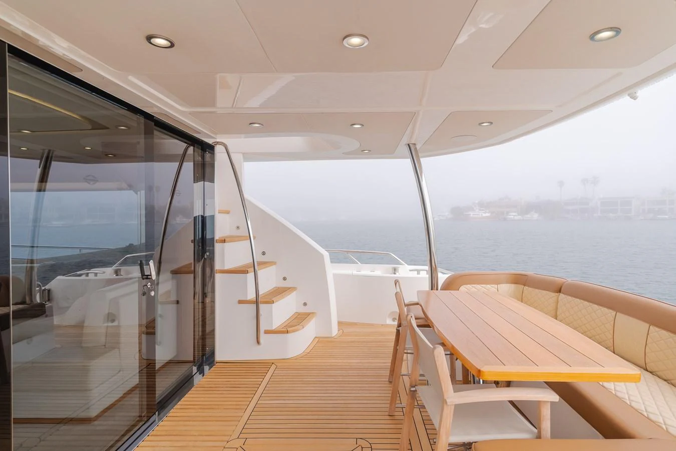 The aft deck features a stylish dining area with a wooden table and comfortable seating, perfect for alfresco meals. aboard AGUA RANCHO Yacht for Sale