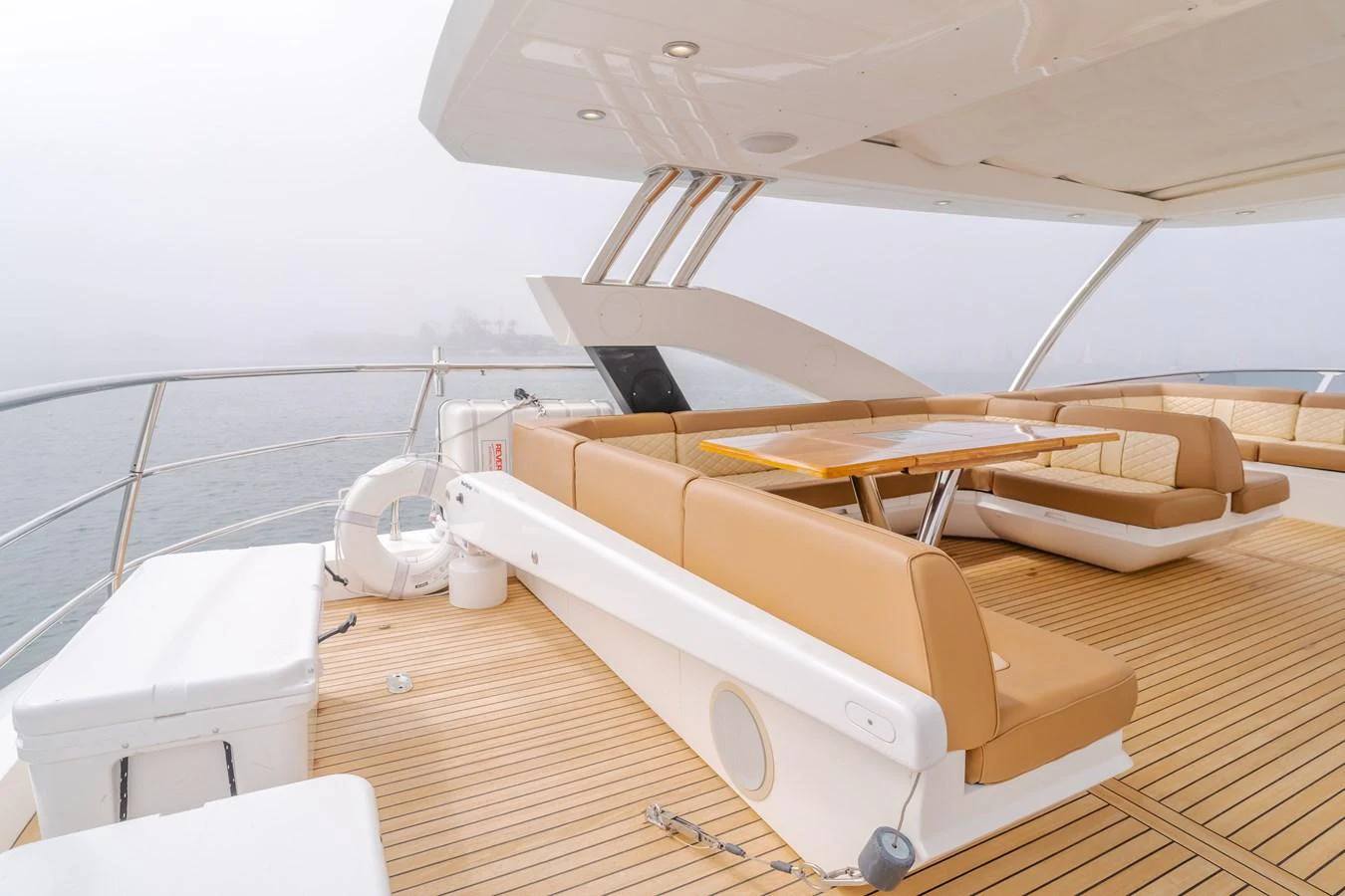 The flybridge offers a spacious and elegant outdoor seating area with a dining table, perfect for enjoying meals with a view. aboard AGUA RANCHO Yacht for Sale