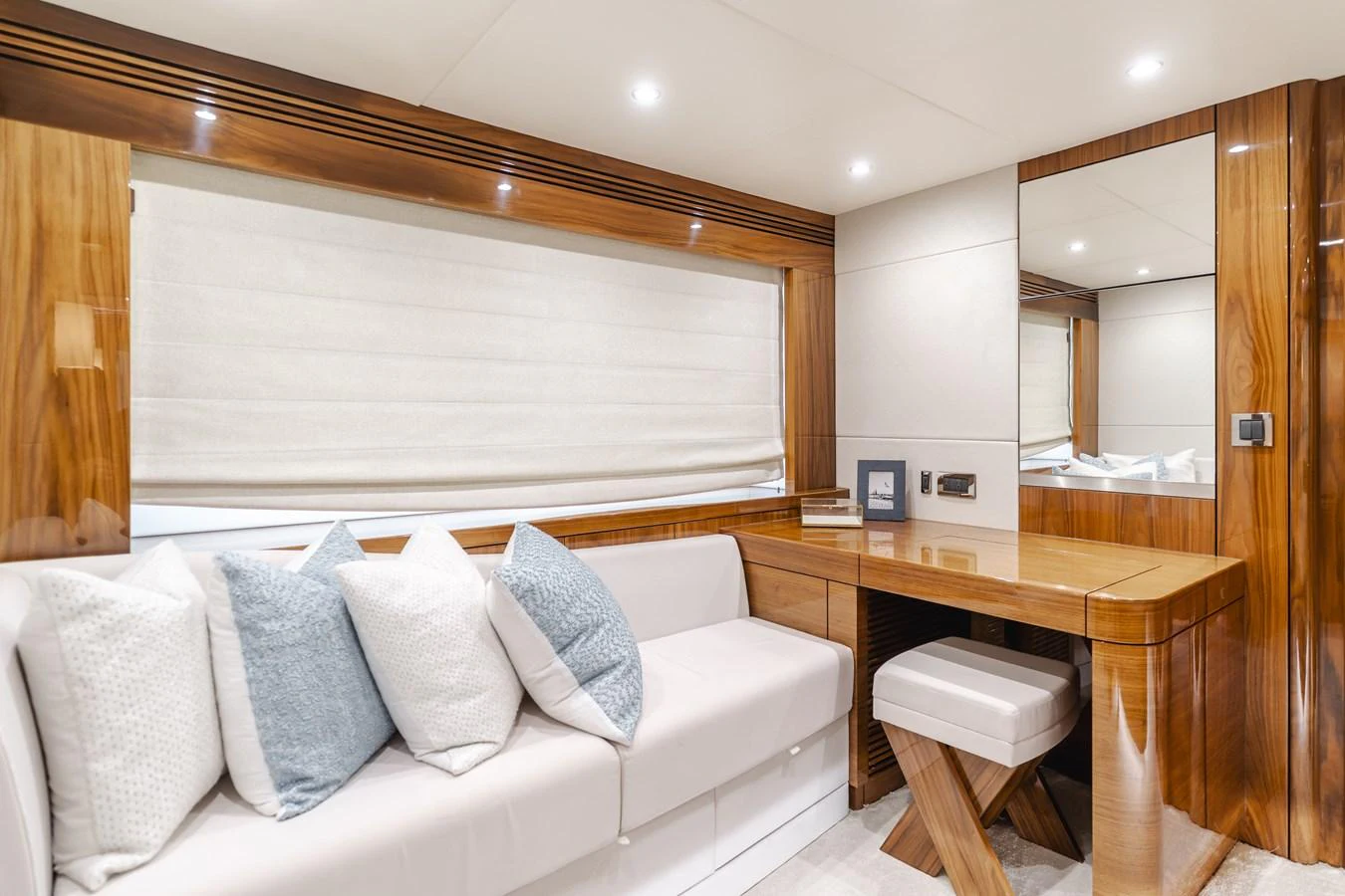 The yacht's interior features a cozy seating area with plush cushions and a sleek wooden vanity. aboard AGUA RANCHO Yacht for Sale