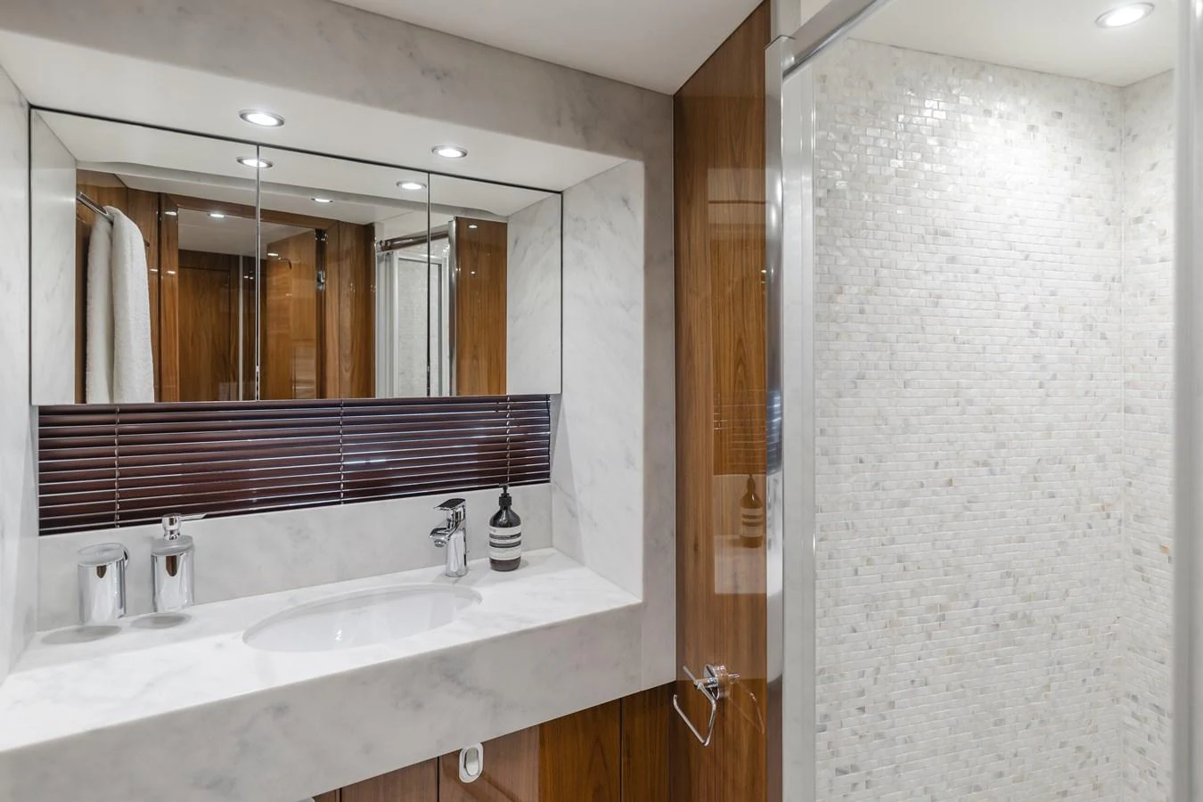 The yacht's bathroom features a sleek, modern design with a marble countertop and a glass-enclosed shower. aboard AGUA RANCHO Yacht for Sale