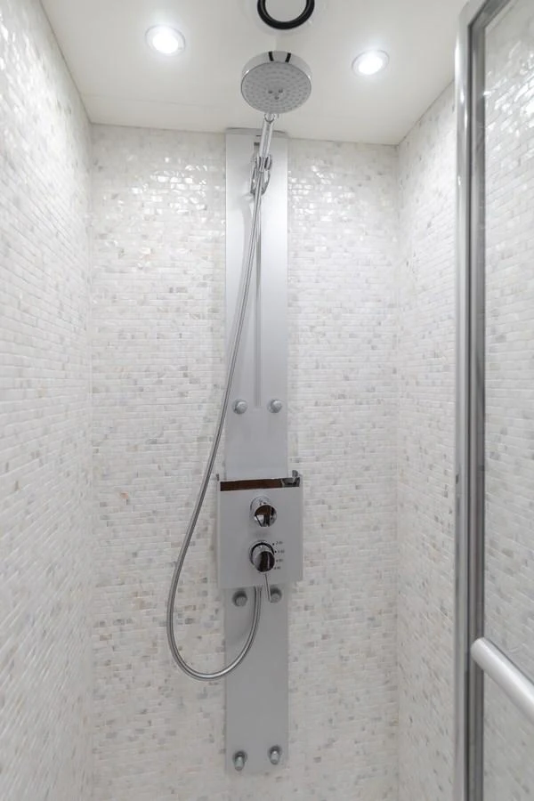 A sleek, modern shower with a rainfall showerhead and elegant tile work. aboard AGUA RANCHO Yacht for Sale