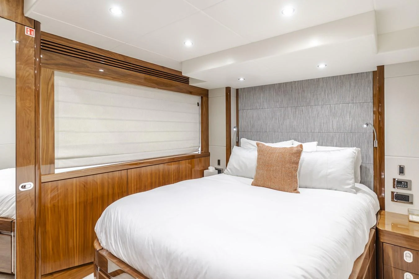 The stateroom features a plush bed with elegant wood paneling and modern lighting. aboard AGUA RANCHO Yacht for Sale