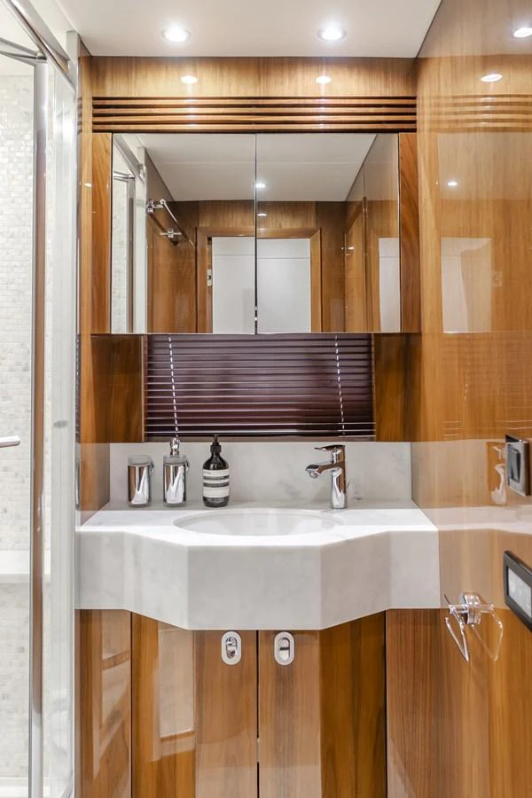 The yacht's bathroom features sleek wooden cabinetry and modern fixtures. aboard AGUA RANCHO Yacht for Sale