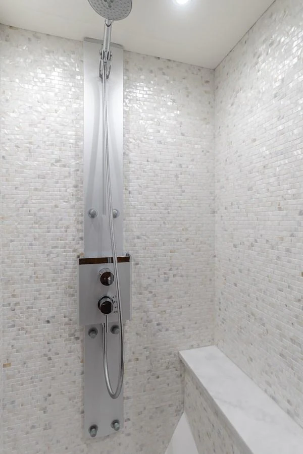 The yacht features a modern shower with sleek fixtures and a mosaic tile design. aboard AGUA RANCHO Yacht for Sale