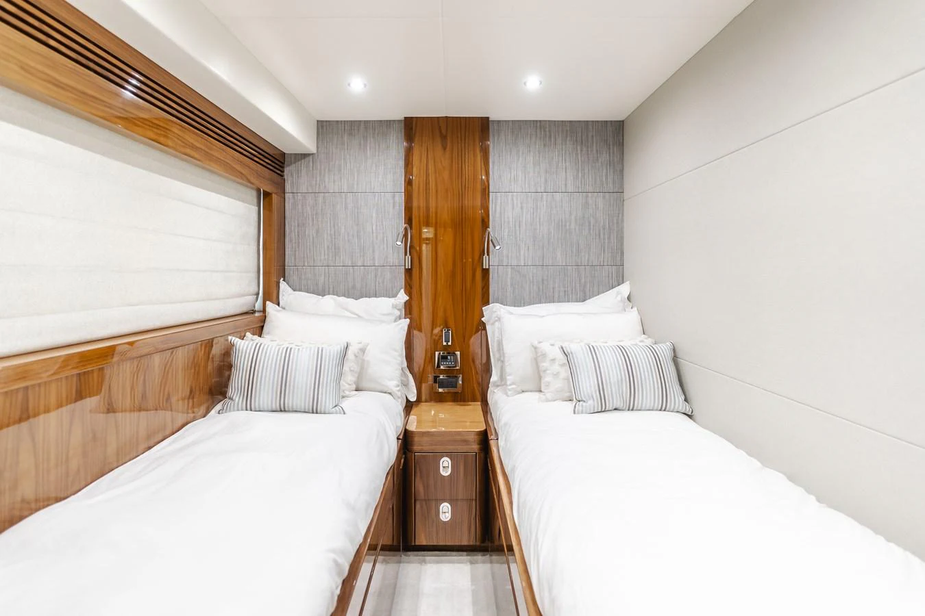 The twin stateroom features two comfortable single beds with elegant wood finishes and soft lighting. aboard AGUA RANCHO Yacht for Sale
