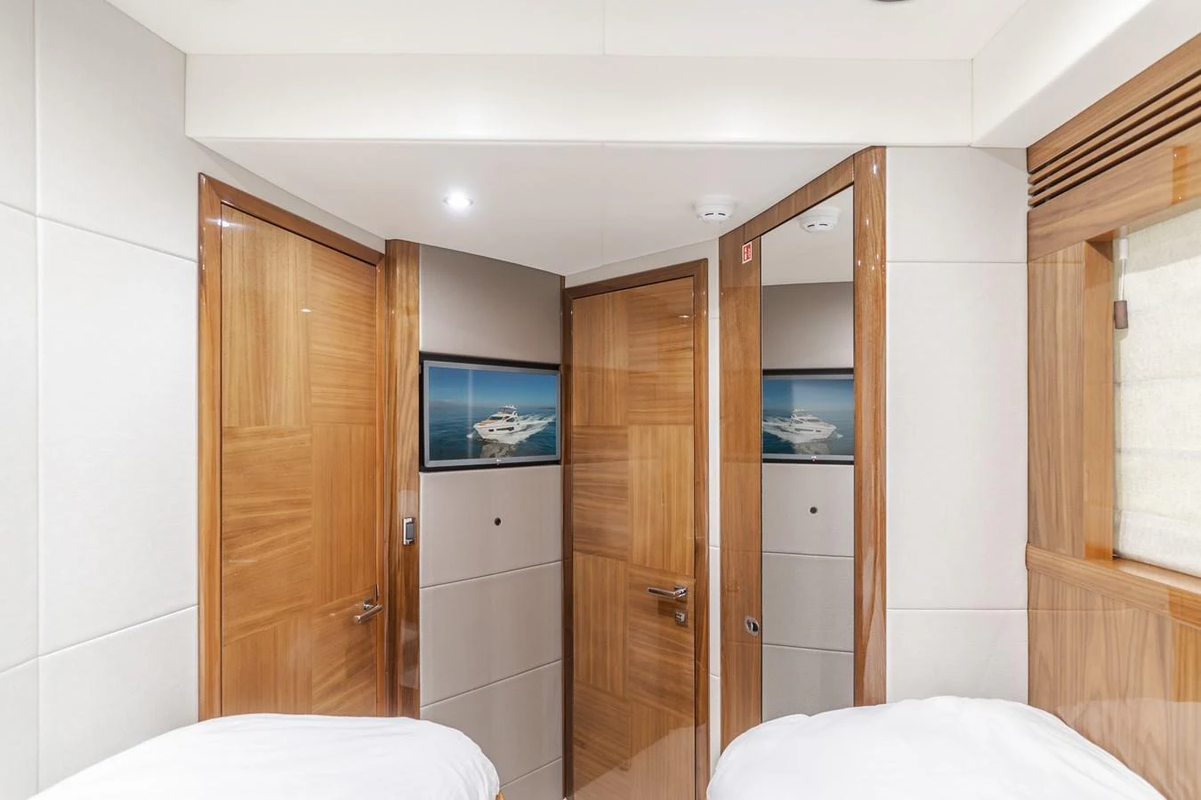 The image showcases a well-lit interior hallway with wooden doors and a framed picture of a yacht. aboard AGUA RANCHO Yacht for Sale