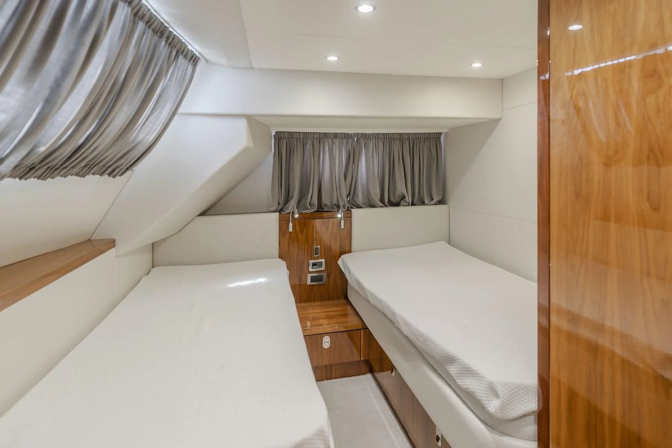The twin stateroom offers a cozy and comfortable sleeping area with two single beds and elegant wood finishes. aboard AGUA RANCHO Yacht for Sale