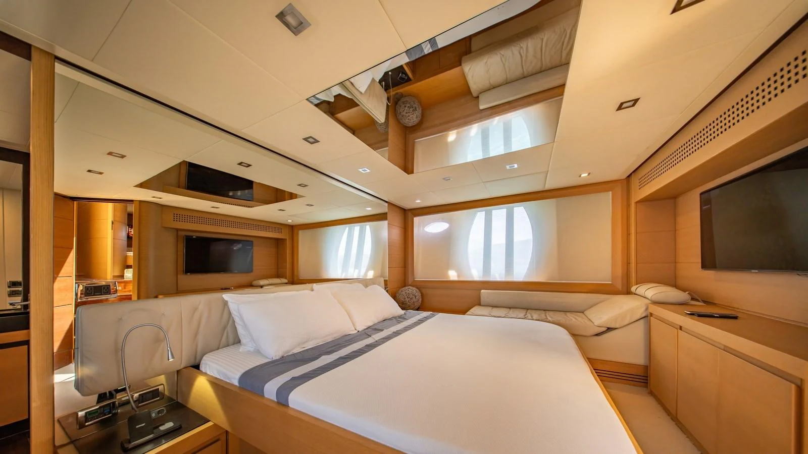 The master stateroom features a spacious bed, modern lighting, and ample natural light from large windows. aboard FREEDOM 2 Yacht for Sale