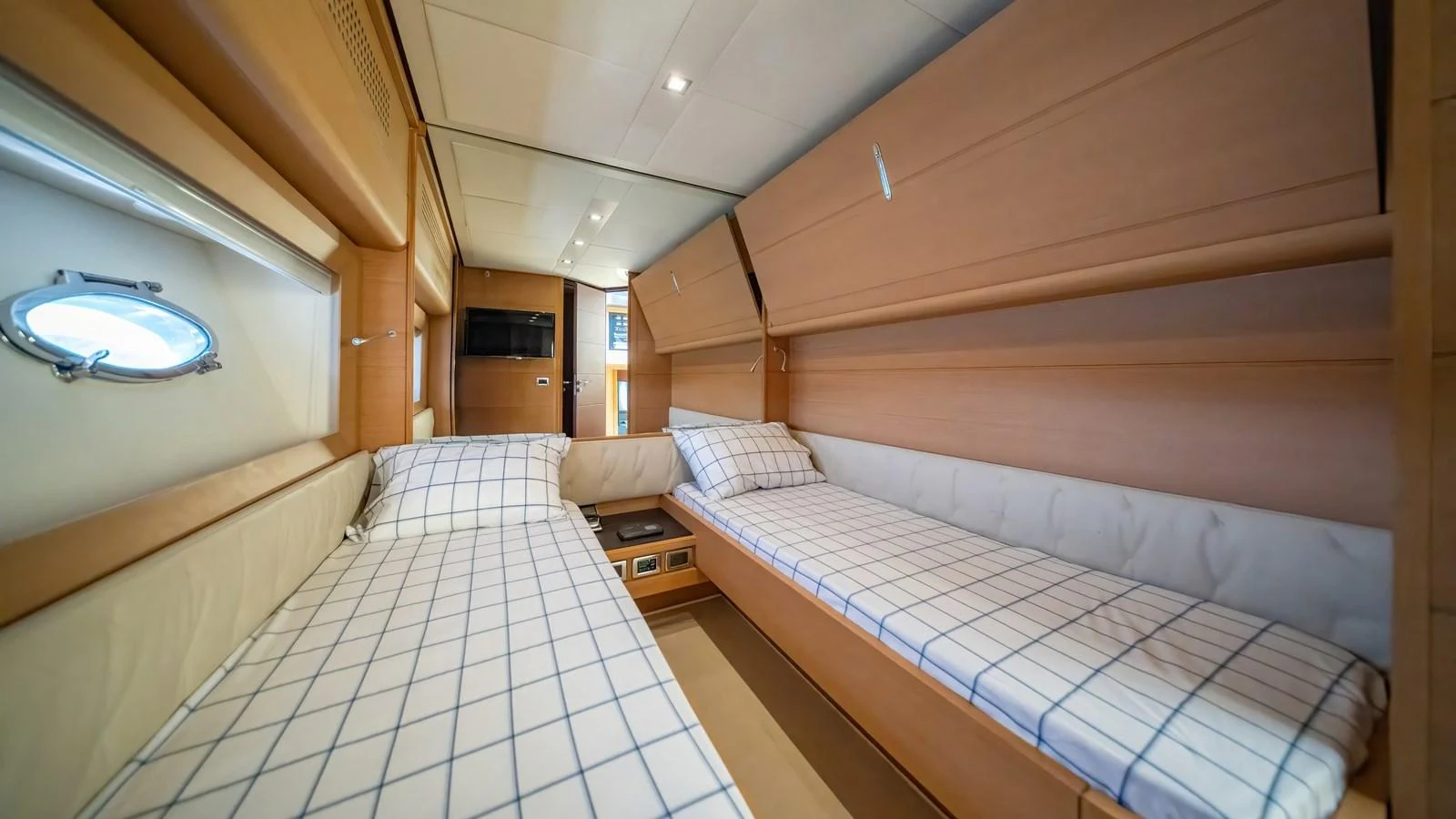 The twin cabin features two comfortable beds with checkered bedding and ample storage space. aboard FREEDOM 2 Yacht for Sale