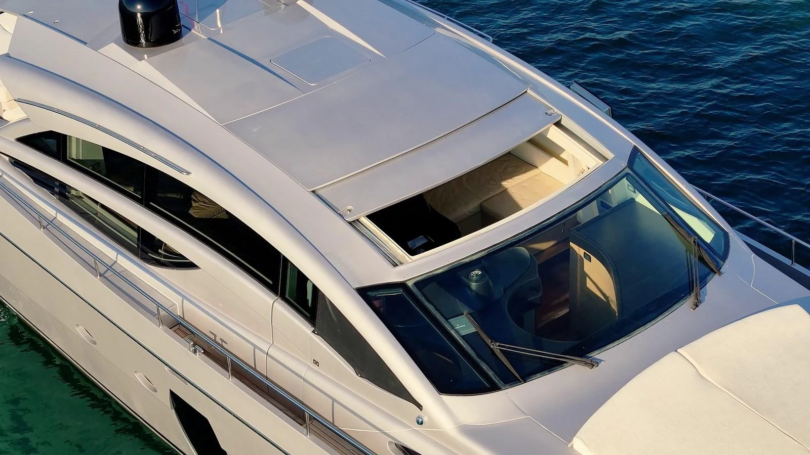 A sleek and modern yacht with a streamlined design and expansive windows cruising on calm waters. aboard FREEDOM 2 Yacht for Sale